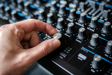 A professional DJ tuning music mixer, sound engineer mixing music on audio mixer tools, song...