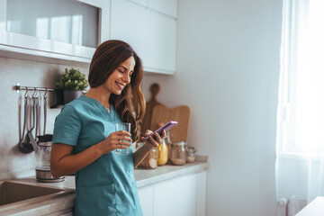 Smiling Woman In Scrubs Enjoying A Break With Phone And Drink