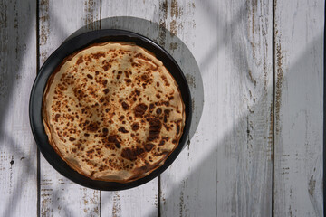 Stack of thin crepes on a wooden board