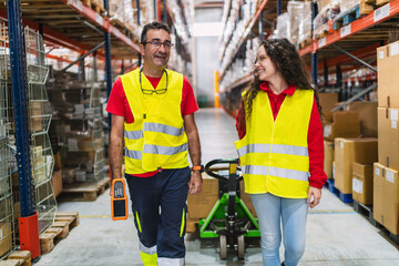 Warehouse workers walking and using handheld computer and pallet jack © Koldo_Studio