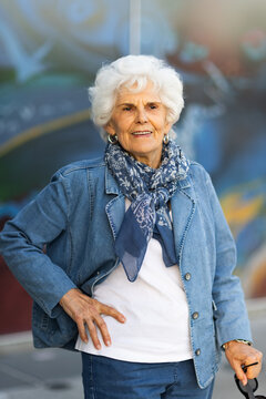 elderly lady wearing denim standing with hand on hip in blue toned image