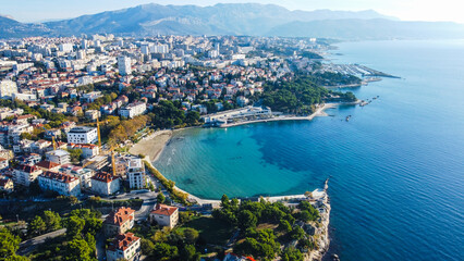 Visão aérea da praia Bacvice em Split, Croácia, mostrando a beleza das águas cristalinas do mar Adriático, a movimentação turística e o charme da cidade costeira