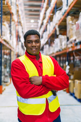 Warehouse worker smiling with arms crossed in logistics center