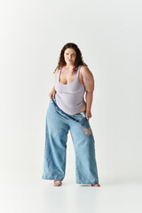 Stylish young woman confidently poses in oversized denim at a minimalist studio setting