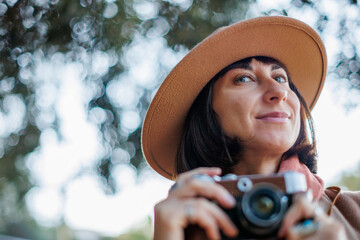 young woman with a film camera. Hipster tourist woman with camera. the girl takes photographs with...
