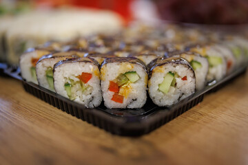 Fresh delicious sushi.Sushi on a black plastic backing.