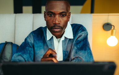 Focused male student studying in a library, concentrating on his work with determination