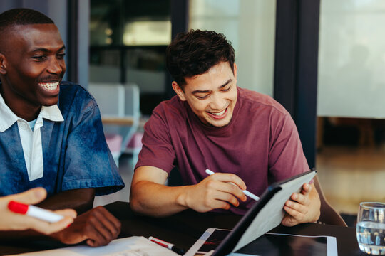 College students engaged in collaborative learning with technology, enjoying a productive study session using a digital tablet