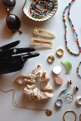 Hand figurine, sunglasses, gold jewelry, colorful bead jewelry, statement rings and various hair...