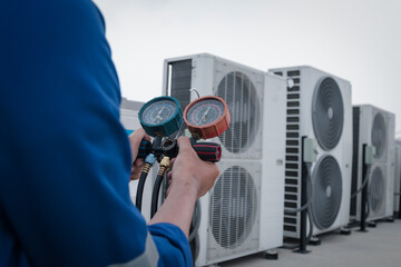 Technician is checking air conditioner,measuring equipment for filling air conditioners.