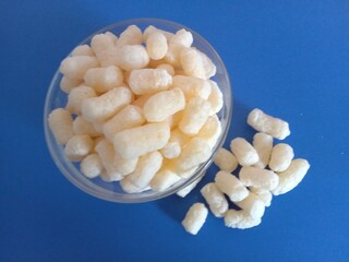 Corn crisps in a plate, blue background