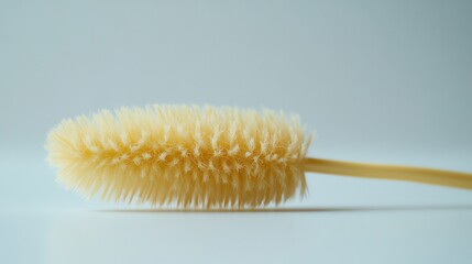Obraz premium A yellow, cylindrical brush with bristles on one end.