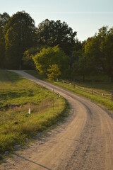 European rural country road landscape with green fields and garden around