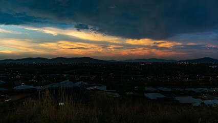 Experience the Dramatic Sunset Over the Hills with a Stunning Urban Landscape in Sight