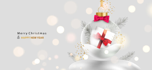 Merry Christmas background. Glass transparent ball with gift box and snow inside. Holiday card with glossy snowball and silver branches on bokeh light. Vector x-mas design.