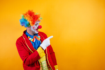 Smiling clown pointing, vibrant yellow background, fun.