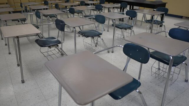 The empty classroom features neatly arranged desks and chairs creating a conducive environment for education. Sunlight may be filtering through the windows enhancing the atmosphere.