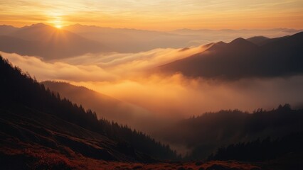 Obraz premium A serene sunrise scene with a mountain range shrouded in mist and fog filling the valley below
