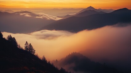Obraz premium A serene sunrise scene with a mountain range shrouded in mist and fog filling the valley below