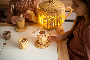 Tea garden party for kids. girls play tea drinking in a beautiful children's room. Children eat sweets.