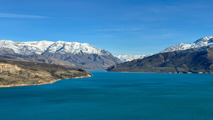 Fototapeta premium reservoir in the mountains with snowy peaks