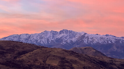 Snowy peaks mountains at the sunset