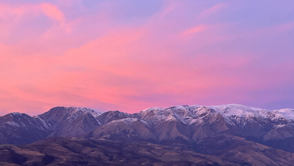 Snowy peaks mountains at the sunset