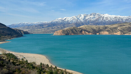 reservoir in the mountains with snowy peaks
