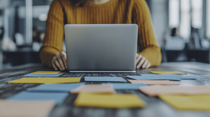 collaborative office environment with laptop and sticky notes