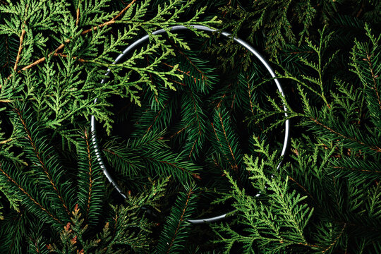 Christmas mockup with pine branches and a metallic ring on a dark background creating a festive and cozy atmosphere