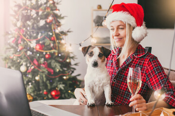 Obraz premium Woman having video call at laptop near Christmas tree