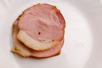 Cold Smoked pork sirloin meat on the white plate. Closeup.