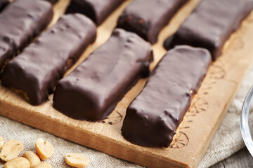 Homemade no-bake protein bars made of whey protein powder and peanut butter coated in chocolate