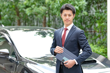 車の前に立つビジネスマン