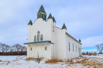 A white church with a green roof and a steeple