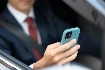 車内でスマホを操作するビジネスマン手元