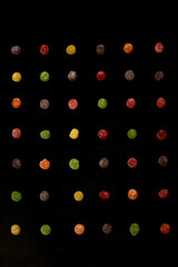 Colorful gummy candies neatly aligned on a black background, forming a modern and organized pattern. Ideal for branding, digital art, or food product campaigns.
