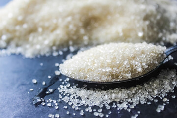 close-up of a spoon full of granulated sugar