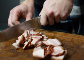 Man slicing smoked bacon close-up
