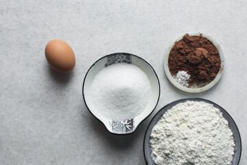 Overhead view of ingredients for making chocolate cookies, top view of mise en place of ingredients for making chocolate sugar cookies, process of making chocolate cookies