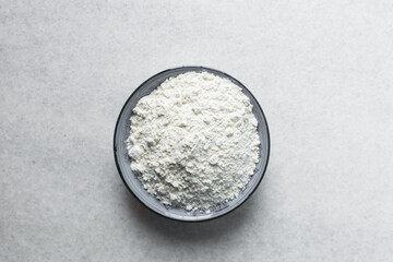 Overhead view of All purpose flour in a plate, baking flour in a plate on a marble countertop