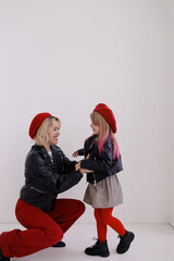The girl looks at the girl and wants to hug her. The girl is dancing, They are dressed in red hats and very beautiful