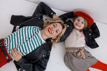 mother and daughter are lying on the floor, wearing red items of clothing
