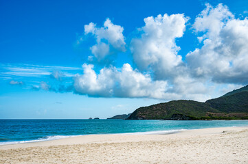 beautiful beach with a blue ocean and a mountain in the background
