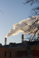 Industrial Chimney with Steam. The contrast between the smoke and the clear blue sky highlights the raw, mechanical side of industry.