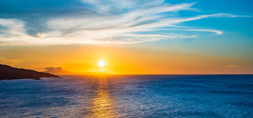 A beach with a small hill in the background