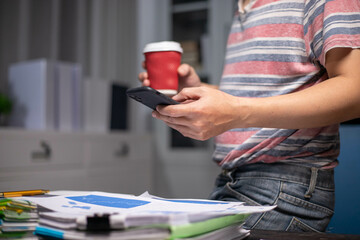 Accountant working at home at night, casual financial investment on a calculator, calculating, analyzing business and marketing growth on various financial document data graphs.