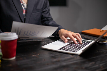 Accountants working on financial investments on calculators, calculating, analyzing business and marketing growth on graphs of various financial documents.