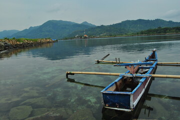 Obraz premium small boat on the beach with clear water and blue sky