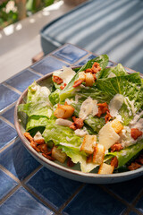 Close up shot of caesar salad with crispy bacon and parmesan cheese